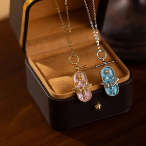 French style titanium steel bee enamel pendant necklaces in pink and blue displayed in a box