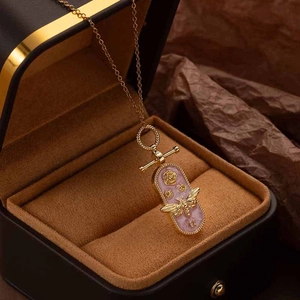 Detailed macro view of vintage gold pendant with bee, rose relief and stylish OT toggle clasp