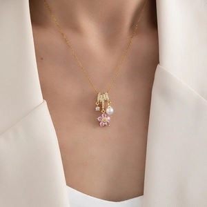 Golden titanium steel necklace with pink zircon flower and pearl worn by a model