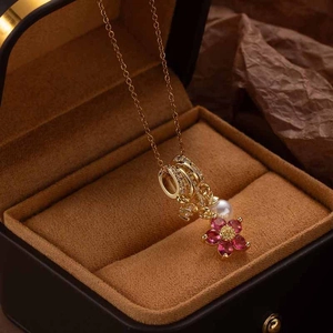 Elegant gold necklace with pearl and purple five-petal flower pendant on display