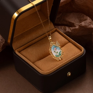 Détail du pendentif tulipe vintage ovale avec émail floral et accents de papillon