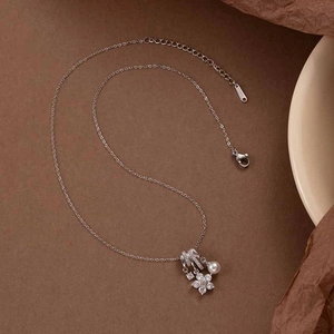 Macro shot of S925 silver necklace featuring a zircon flower, pearl and logo tag