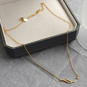 Élégant collier ondulé plaqué or avec zircons et breloque étoile sur une boîte à bijoux