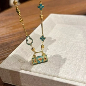 Détail macro du pendentif cylindre en émail bleu sur un collier doré mat