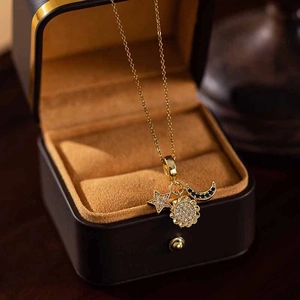 Close-up of golden sunflower necklace with sparkling star, sun, and moon zircon pendants