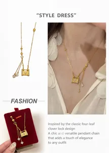Détail d'un collier à pompons dorés avec pendentif serrure et breloques trèfle