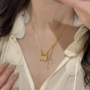 Collier élégant avec pendentif serrure trèfle doré et pompons pour femme