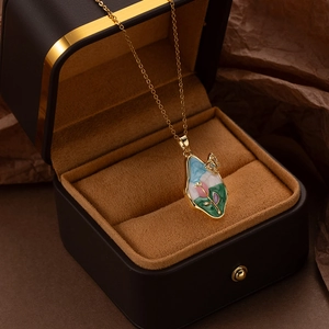 Macro detail of French style enamel floral necklace with gold butterfly in a gift box