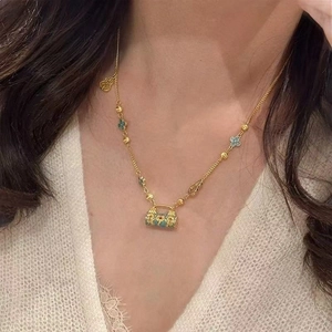 Collier médaillon émaillé bleu doré porté sur un vêtement en dentelle délicate
