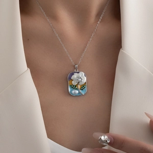 Makroaufnahme der französischen Vintage-Emaille-Halskette mit weißer Blume und Perle