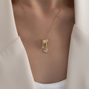 Elegante goldene Schmetterlingskette mit Zirkonia-Anhängern am Hals des Models