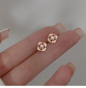 Detail of four-leaf clover stud earring with white pearl and sparkling crystals