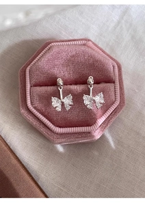 Detail view of bow earrings with zircons in a pink velvet jewelry box