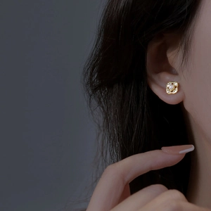 Elegant gold flower stud earring with diamonds and pearl on model side profile