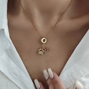 Collier doré exquis avec pendentif empreinte en zircon et cœur rouge sur un mannequin