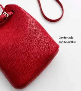 Detail einer roten Eimer-Tasche aus genarbtem Leder mit silbernen Beschlägen