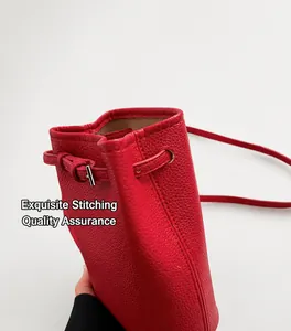 Detail der roten Eimer-Tasche aus genarbtem Leder mit feinen Nähten und Schnalle
