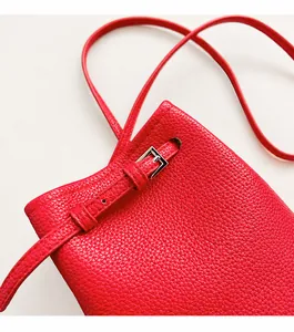 Detail der roten Handy-Tasche aus genarbtem Leder mit Silberbuckle und Kordelzugverschluss