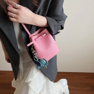 Detailansicht der rosa Mini-Eimertasche aus Leder mit blauem Elefantenanhänger und Metall