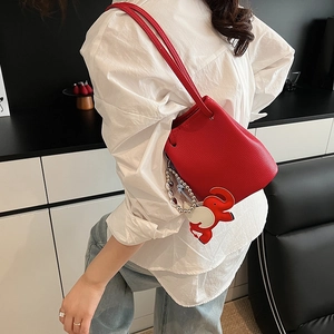 Detail der roten Beuteltasche aus Leder mit Lychee-Narbe und Elefanten-Anhänger