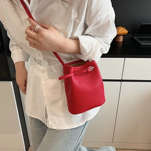 Detailansicht der roten Leder-Eimertasche mit Kieselstruktur an einem Model im Alltag