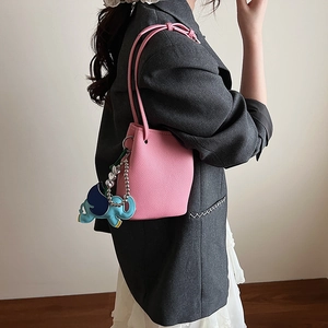 Rosafarbene Bucket Bag mit Lychee-Struktur und süßem blauem Elefanten-Anhänger Detail