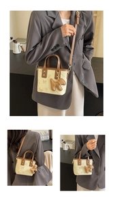 Detail of a chic two-tone mini tote bag with butterfly prints and a puppy charm