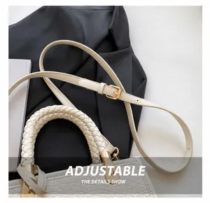 Détail de la bandoulière réglable et de la poignée tressée du sac seau blanc chic