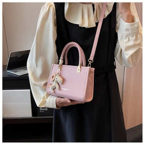 Détail du sac seau rose clair avec texture autruche et breloque cheval mignonne
