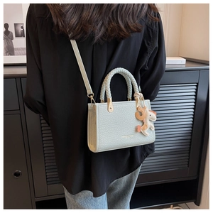 Détail du sac seau vert menthe avec poignée tressée et petit pendentif cheval