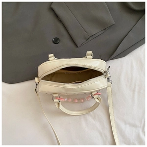 Top view of cream white mini boston bag showing interior compartment and metal zipper