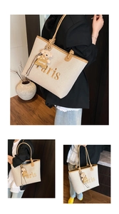 Detail of canvas tote bag with brown leather trim, Paris embroidery and bear charm