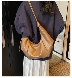 Detail of caramel brown soft leather hobo bag with stylish knotted shoulder strap