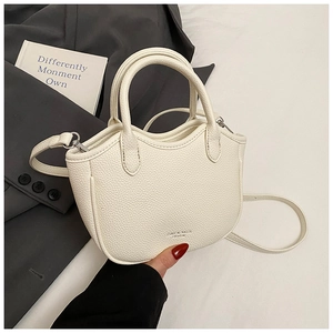 Close-up of cream white lychee texture handbag with logo and adjustable shoulder strap