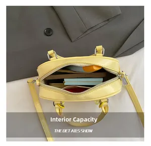 Macro view of the internal capacity of this yellow leather Boston bag showing storage space