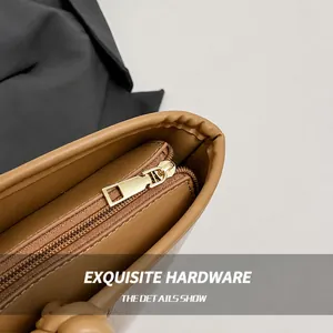Detailed macro view of golden metal zipper and stitching on the brown canvas bucket bag