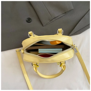 Internal storage view of yellow bowling bag with phone and cosmetics inside