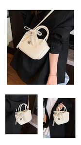 Close-up of cream mini handbag with lace bow, pearl pendant and lychee leather texture