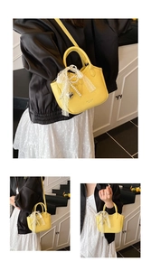 Detail of yellow lychee leather mini handbag with lace bow and pearl heart charm