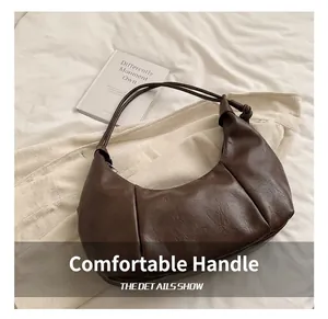 Detailed close-up of dark brown soft leather hobo bag with unique knotted handle design