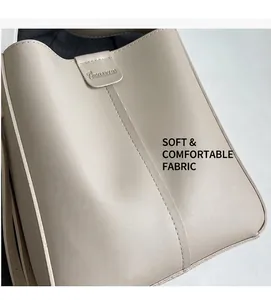Gros plan d'un sac seau en cuir beige avec couture verticale et logo de marque gravé