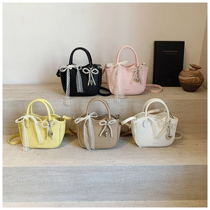 Detailed display of mini tote bags in various colors with lace bows and pearl charms