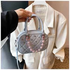 Close-up of diamond lattice stitched mini Boston bag with pearl bow chain in light blue