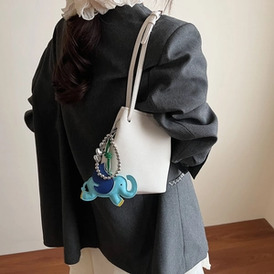 Minimalistische weiße Eimer-Handtasche aus Leder mit blauem Elefanten-Anhänger für Damen