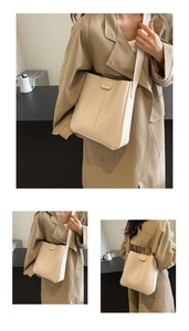Détail du sac seau en cuir crème avec bandoulière réglable et fermoir métallique