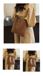Détail du grand sac seau en cuir marron avec rabat magnétique porté sur un manteau beige