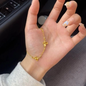 Élégant bracelet papillon doré avec deux pendentifs détaillés dans un cadre lifestyle