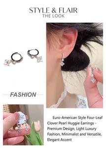 Detail of S925 silver hoop earrings with white pearl and rhinestone clover charm on model