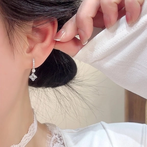 Elegant silver four-leaf clover drop earrings with white pearls and sparkling cubic zirconia