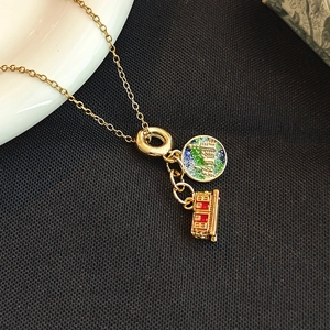 Collier en acier titane avec pendentifs terre en émail coloré et petit train rouge